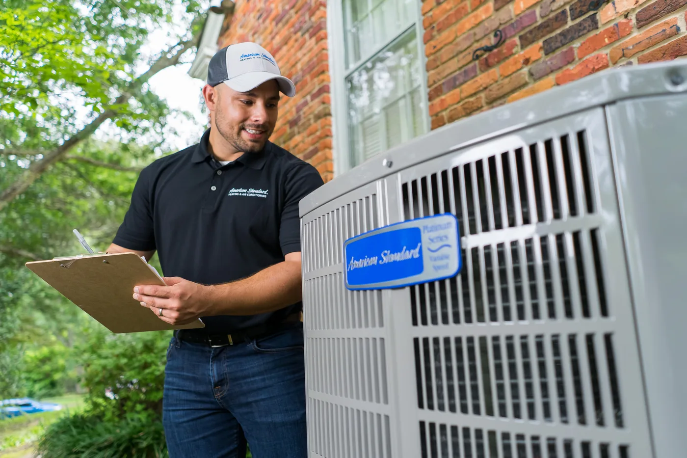 Technician inspecting an outdoor HVAC system